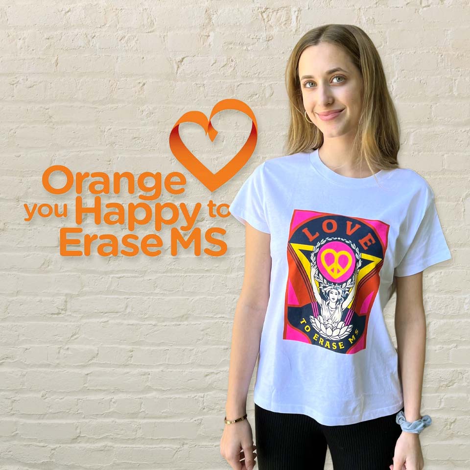Woman wearing a white t-shirt with the 2022 Love to Erase MS graphic